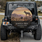 Joshua Tree National Park spare tire cover on a Jeep Wrangler, showing a coyote on a boulder above a desert flat of Joshua trees