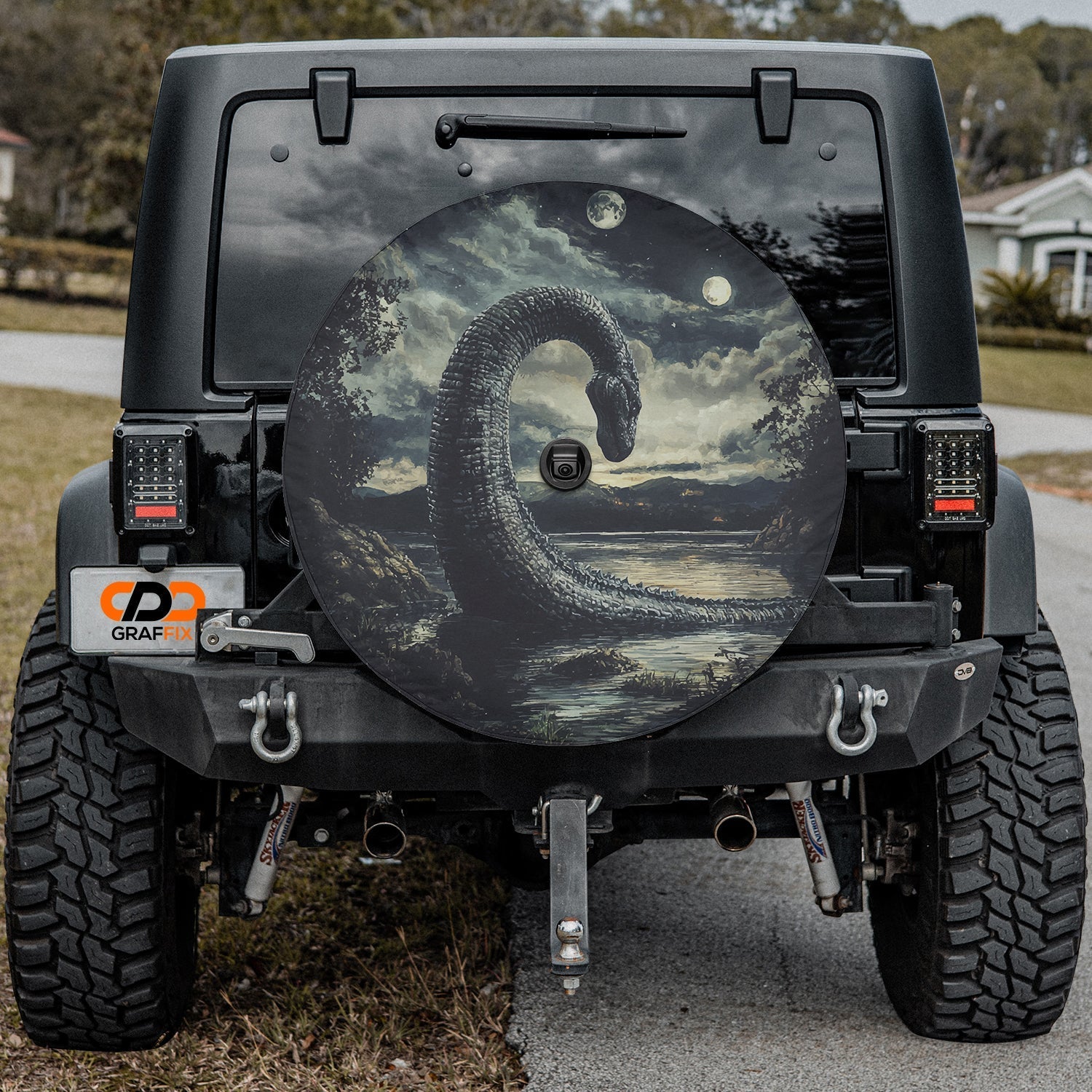 Loch Ness by Moonlight spare tire cover on black Jeep Wrangler rear with serpent rising from misty loch