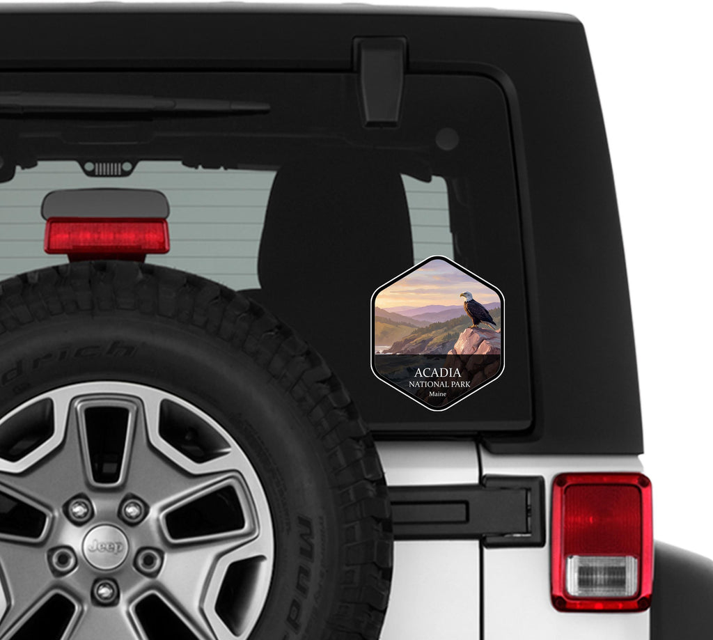 Acadia National Park sticker applied to the rear window glass of a white Jeep Wrangler beside the spare tire