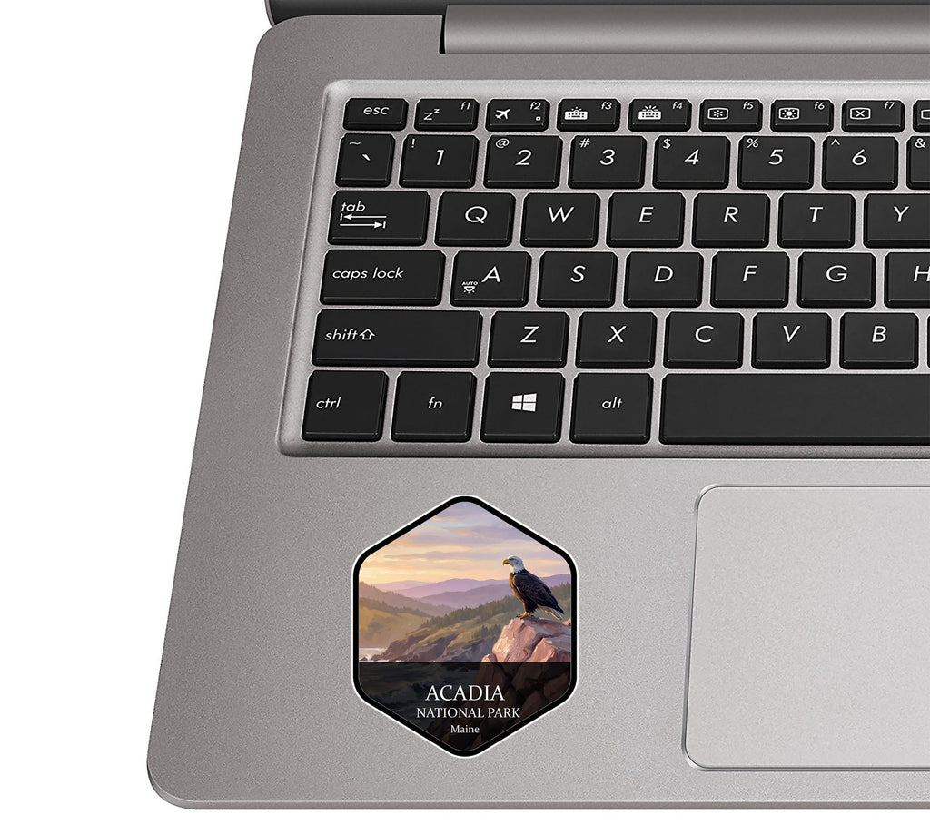 Acadia National Park sticker on the palm rest of a silver laptop next to the trackpad