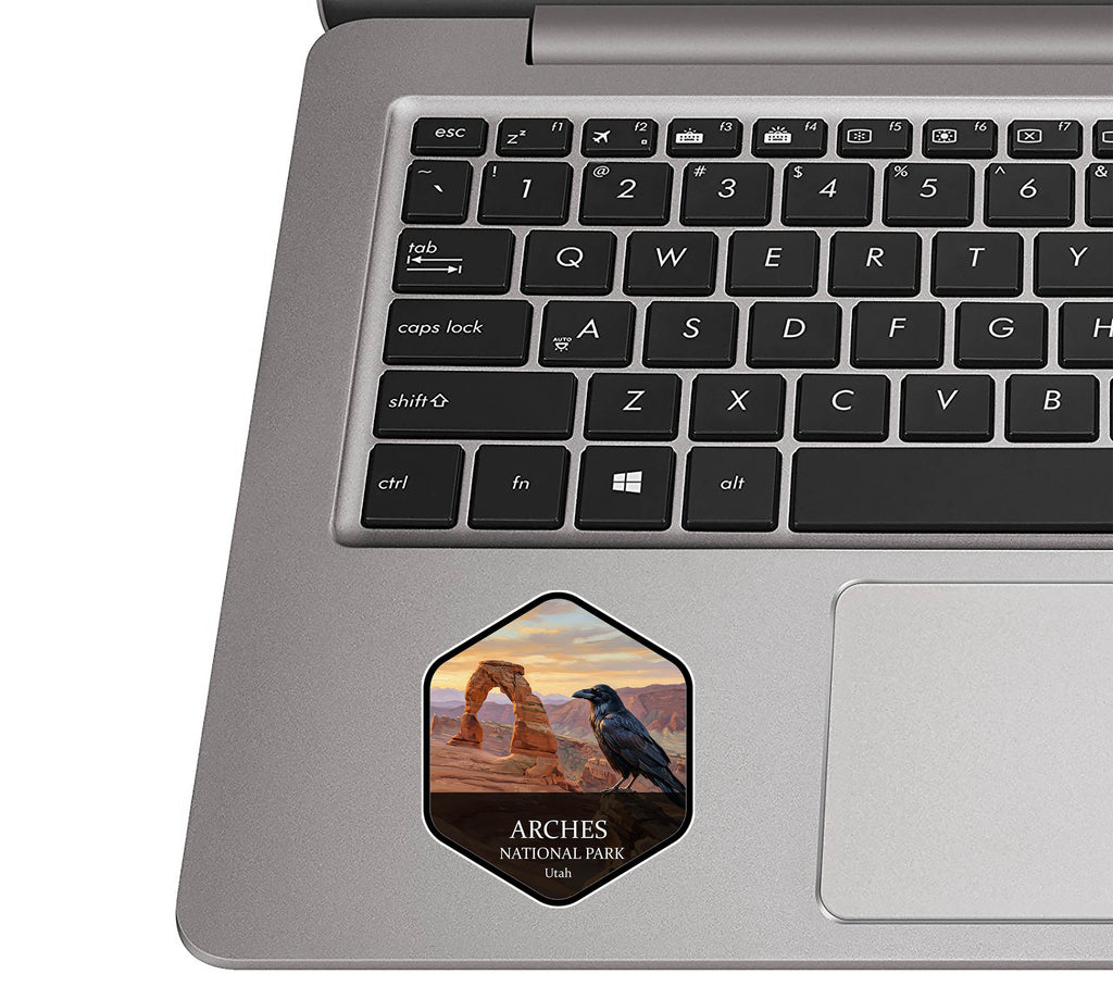 Arches National Park badge sticker applied to the palm rest of a silver laptop