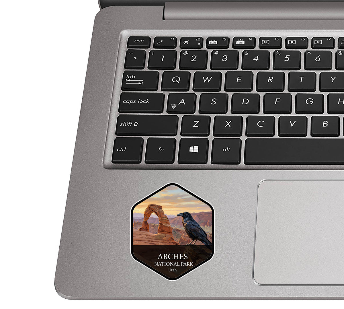 Arches National Park badge sticker applied to the palm rest of a silver laptop