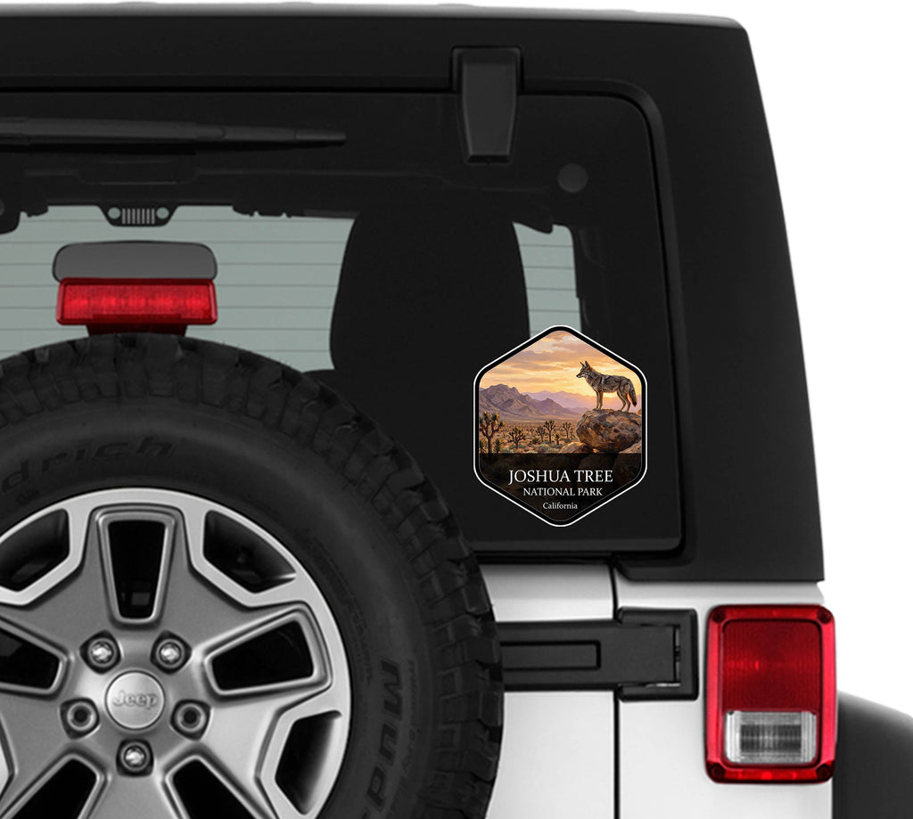 Joshua Tree National Park badge sticker applied to the rear window of a white Jeep Wrangler beside the spare tire