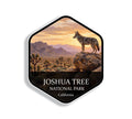 Hexagonal Joshua Tree National Park sticker badge with a coyote on granite boulders among Joshua trees at sunset