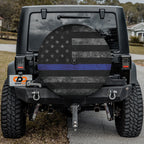 Thin blue line subdued flag tire cover on a black Jeep Wrangler with distressed stars stripes thin blue stripe
