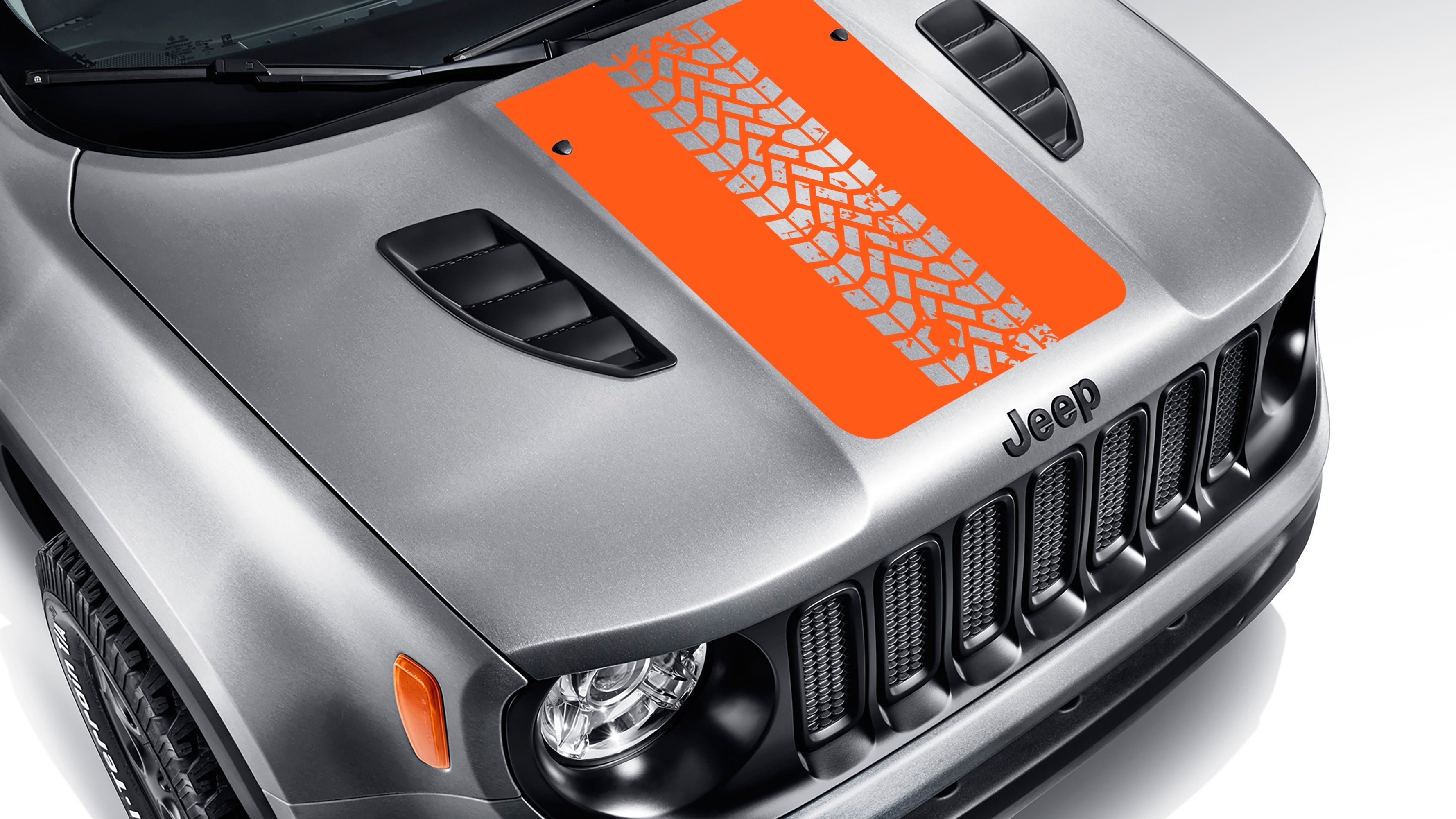 Orange tire track blackout hood vinyl decal on silver Jeep Renegade hood with bold tread pattern