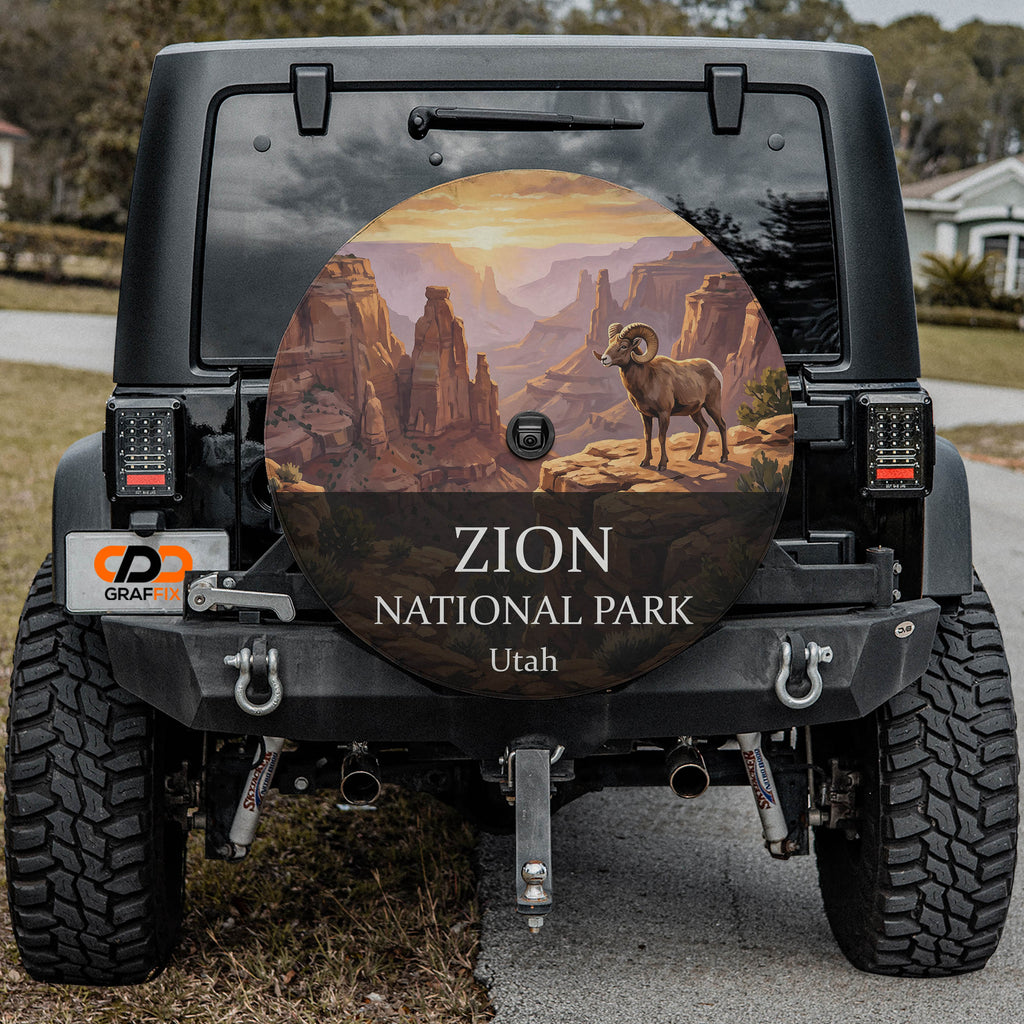 Zion National Park spare tire cover on a Jeep Wrangler, showing a desert bighorn on a ledge above red sandstone canyon walls