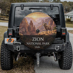 Zion National Park spare tire cover on a Jeep Wrangler, showing a desert bighorn on a ledge above red sandstone canyon walls