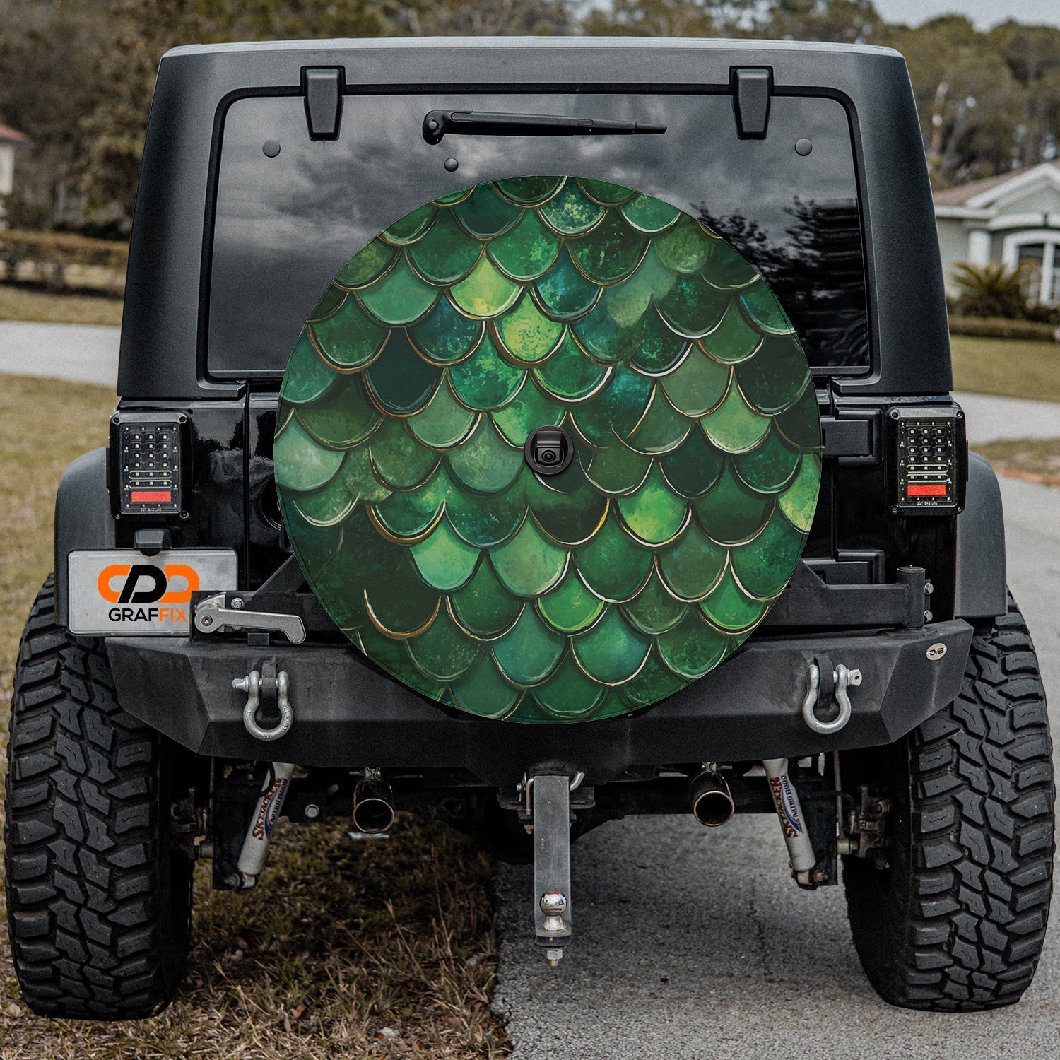 Green mermaid scale spare tire cover installed on a black Jeep Wrangler with GRAFFIX bumper logo display