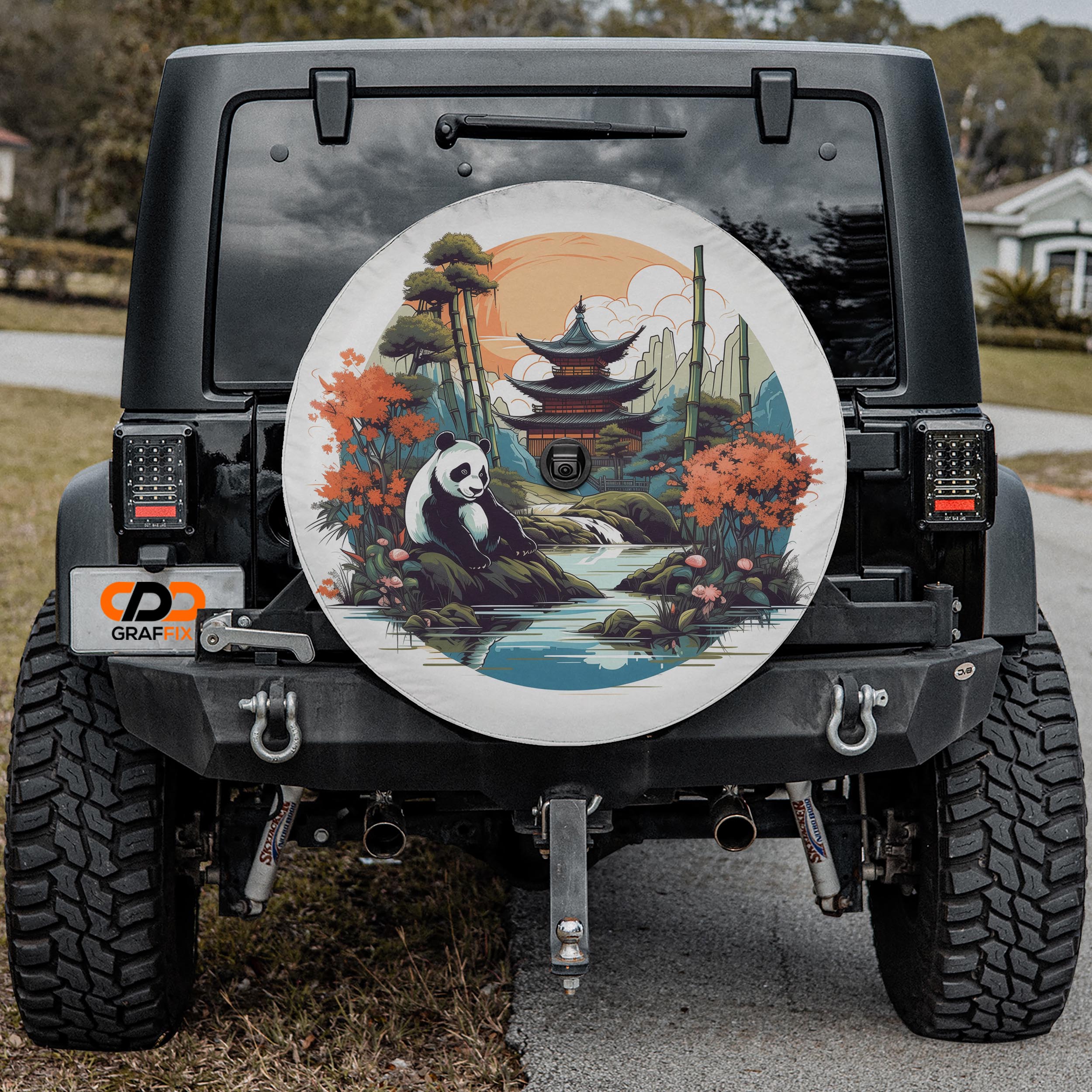 the back of a black Jeep Wrangler with a large, colorful wheel cover featuring a panda bear and a scenic landscape.