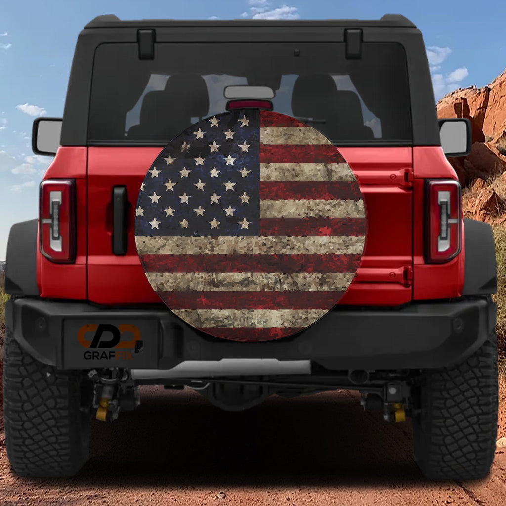 Rustic American flag spare tire cover mounted on red Ford Bronco rear with red rock canyon scenery