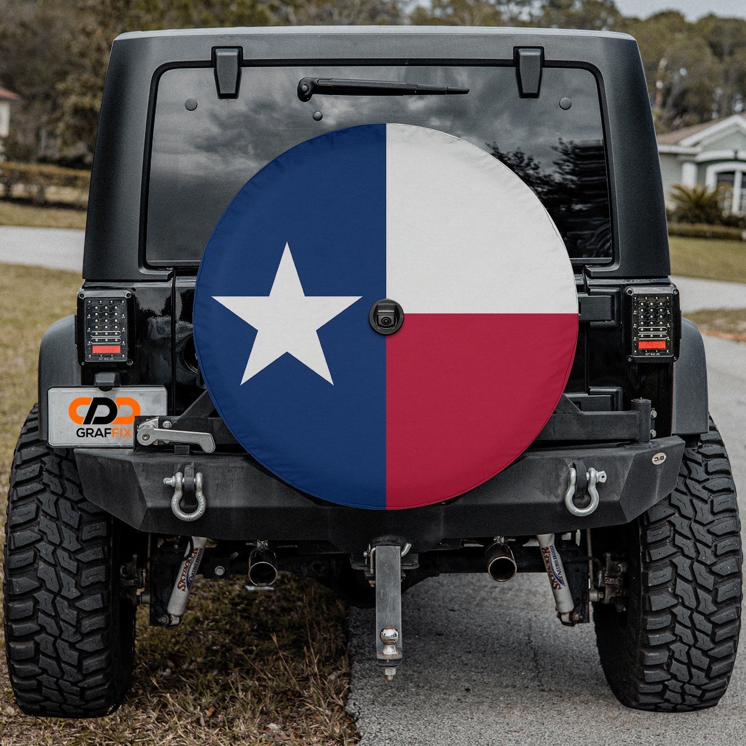 Texas state flag spare tire cover on red Jeep Wrangler with desert backdrop featuring Lone Star design