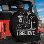 A black tire cover with a cartoon image of a person riding a giant sea creature and the text "I BELIEVE" printed on it.