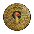 a golden emblem with a bird-like design and a red gemstone at its center.