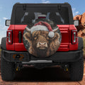 Highland Christmas Cow spare tire cover on a red Jeep Wrangler with shaggy cow in a Santa hat