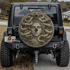 the back of a black Jeep Wrangler with a large, detailed stone carving of a woman's face on the rear window.