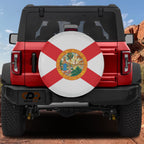 Florida state flag spare tire cover mounted on red Ford Bronco rear with red rock canyon backdrop