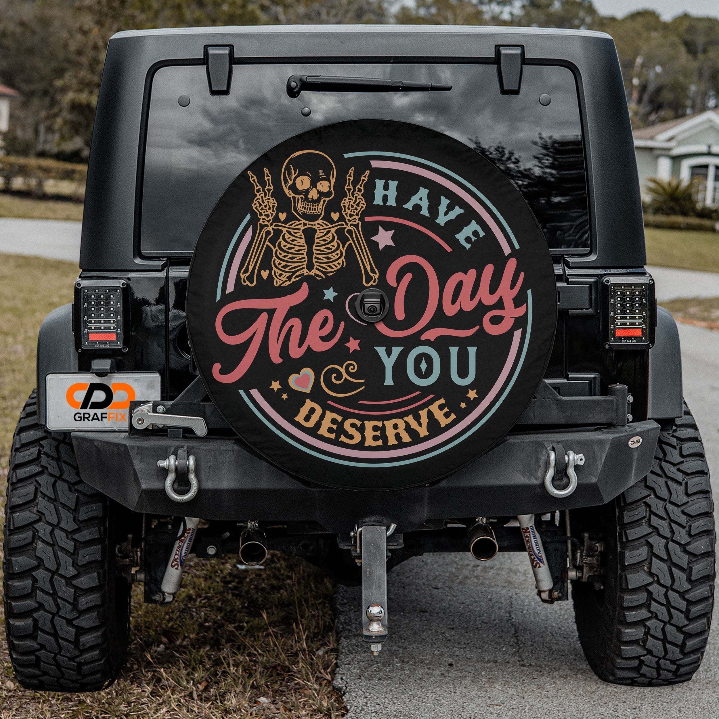 Have the Day You Deserve spare tire cover alternate angle showing rocker skeleton circle badge art