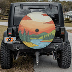 Close-up sunset landscape spare tire cover disc with pine trees, river, mountain art and camera hole