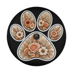 A black wheel cover with a floral design on it, resembling a paw print.