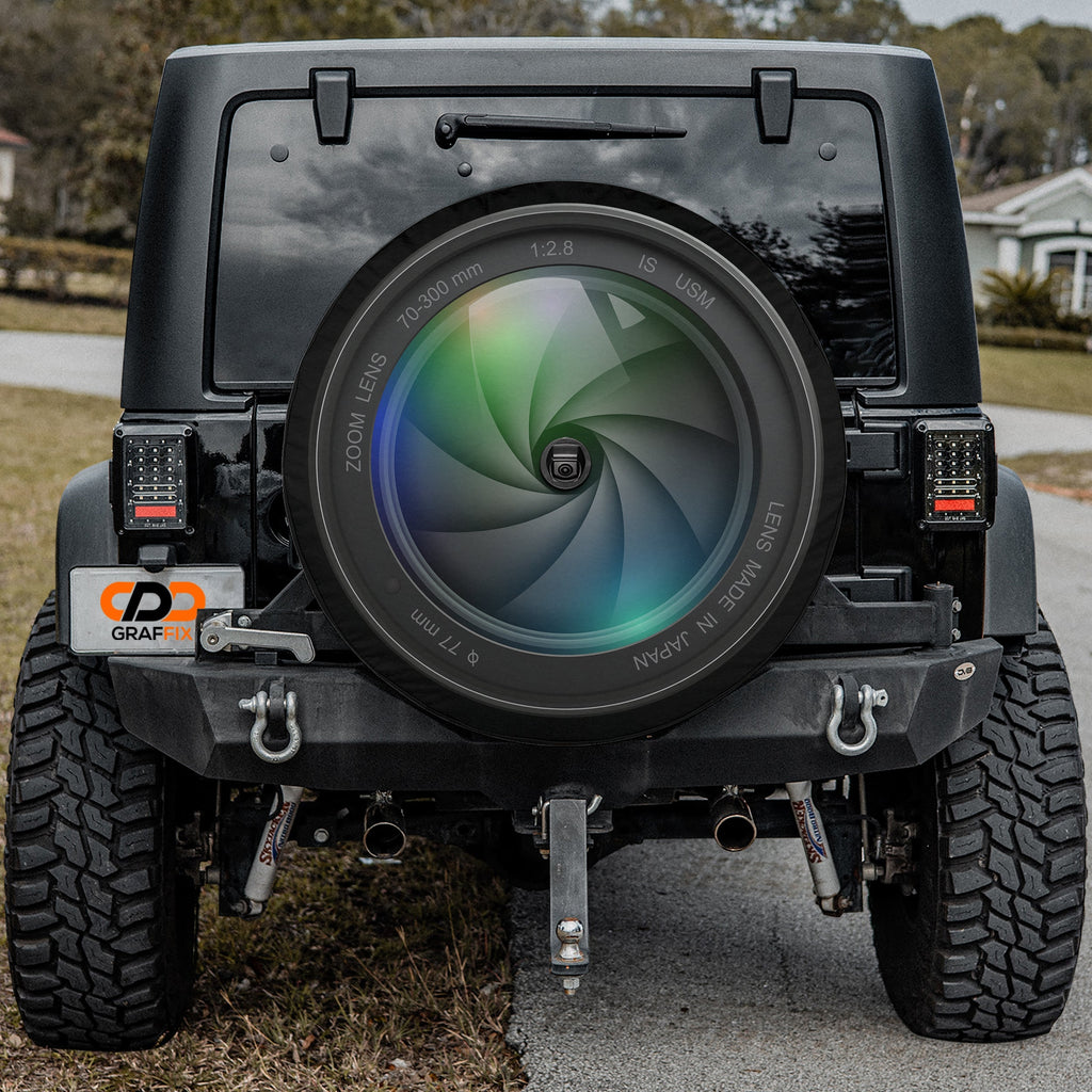 Camera Lens tire cover mounted on Jeep Wrangler resembling giant photographer lens
