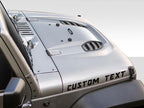 Custom text hood lettering vinyl decal mockup shown on a Jeep Wrangler hood surface in white script