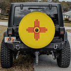 New Mexico State Flag spare tire cover on red Jeep Wrangler showing red Zia sun on yellow background