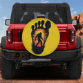 Squatch Track spare tire cover on red Bronco with yellow Bigfoot footprint sunset silhouette design