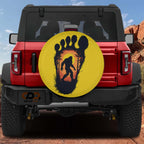 Squatch Track spare tire cover on red Bronco with yellow Bigfoot footprint sunset silhouette design