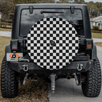 Black and white checkered board spare tire cover on black Jeep Wrangler with CDD GRAFFIX badge