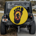 Squatch Track spare tire cover on red Jeep Wrangler featuring Bigfoot inside footprint graphic