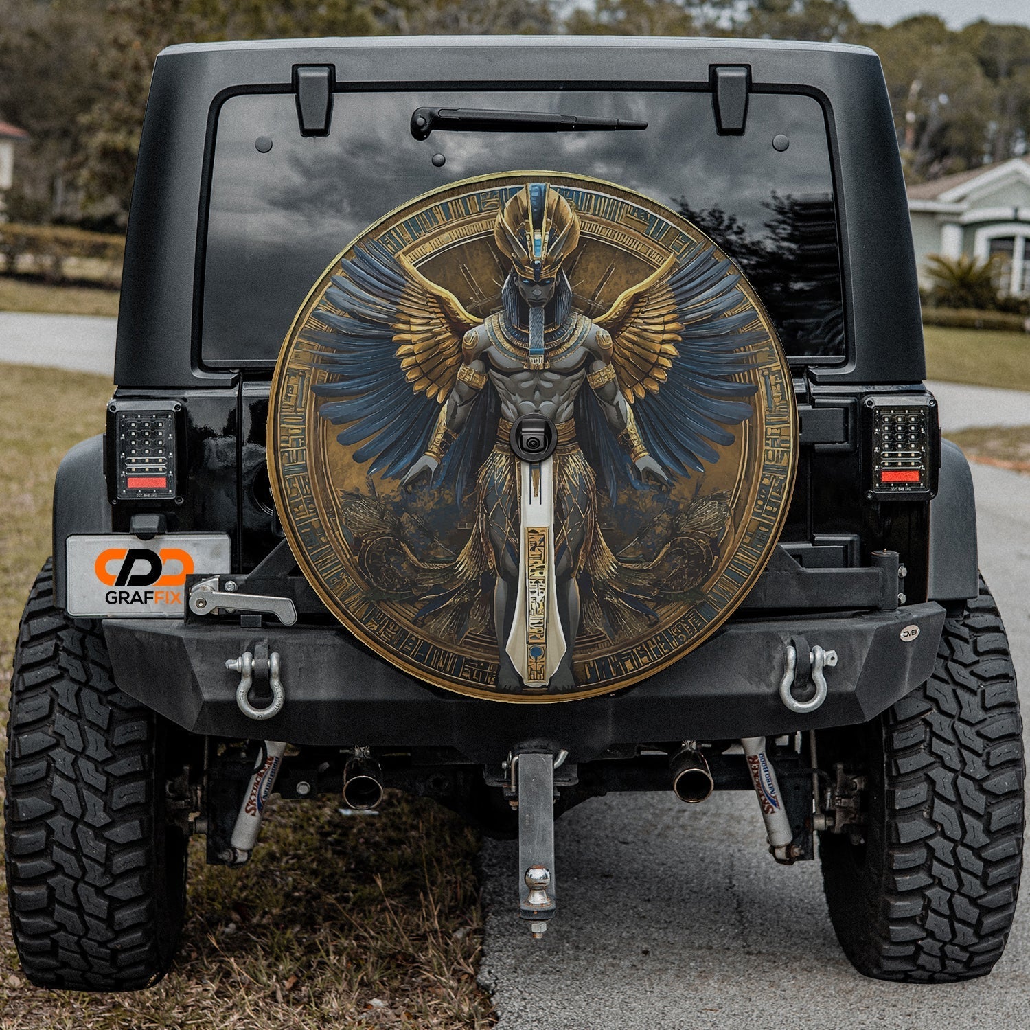 Close-up Egyptian pharaoh winged deity spare tire cover disc showing detailed hieroglyph art and camera hole