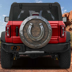 the back of a red Jeep Wrangler with a large wooden horseshoe-shaped spare tire mounted on the vehicle.