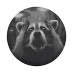 A raccoon with its paws covering its face appears to be in a state of surprise or excitement, with its mouth open and eyes wide.