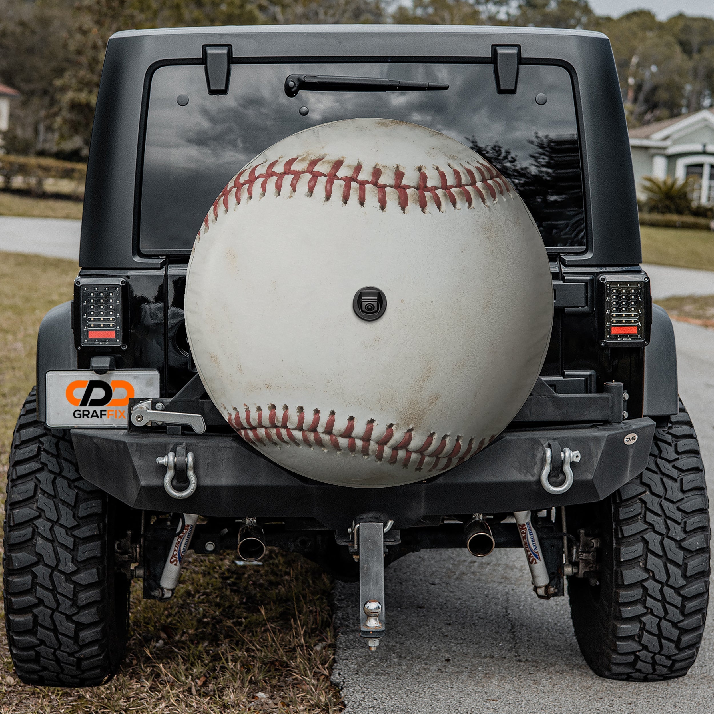 Baseball spare tire cover mounted on black Jeep Wrangler rear with backup camera cutout