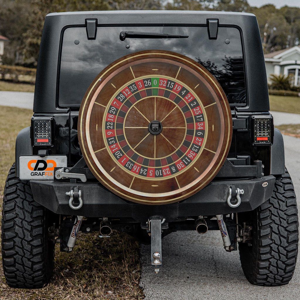 a black Jeep Wrangler with a large, round, and colorful roulette wheel attached to the rear of the vehicle.
