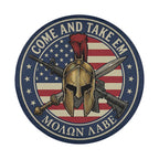 a circular emblem with a helmet, crossed swords, and a banner with the text "COME AND TAKE EM" and "MOËN AÑE" written on it.