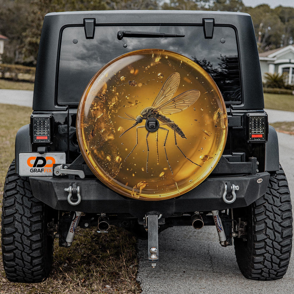 a black Jeep Wrangler with a large, round spare tire attached to the rear of the vehicle. The spare tire has a design of a mosquito on it, which is a unique and eye-catching feature.