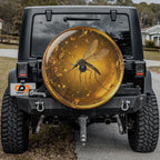 a black Jeep Wrangler with a large, round spare tire attached to the rear of the vehicle. The spare tire has a design of a mosquito on it, which is a unique and eye-catching feature.
