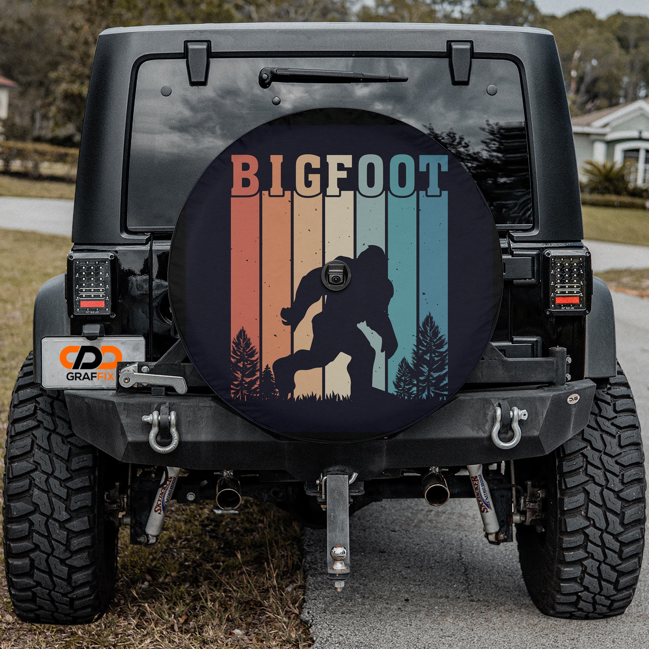 Sasquatch Stripes spare tire cover on red Jeep Wrangler showing striped Bigfoot forest scene art