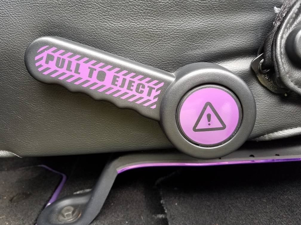 Pink Pull to Eject seat recliner handle decal applied to black Jeep Wrangler JK seat lever