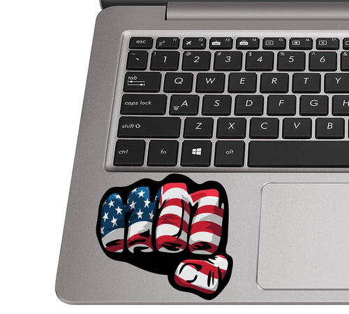Patriotic fist sticker applied to a silver laptop palm rest near the trackpad to show real applied decal size