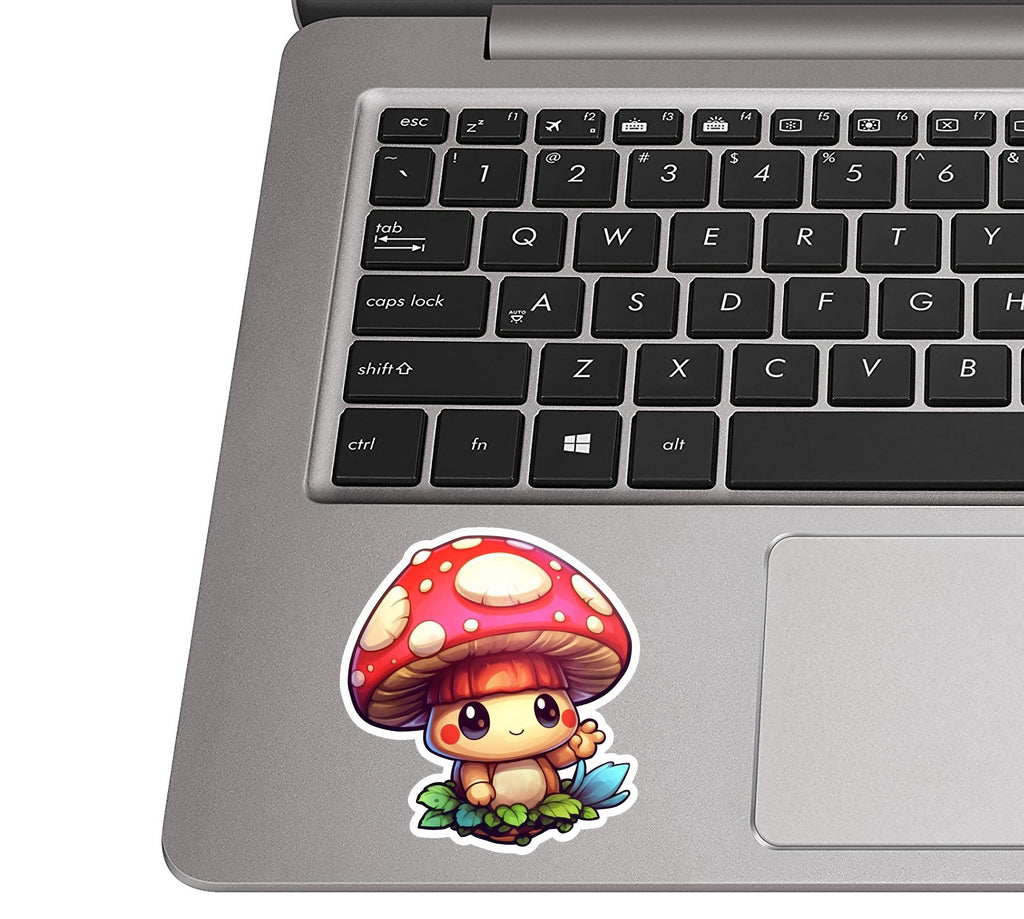 Cute cartoon mushroom sticker on a silver laptop palm rest near a black QWERTY keyboard for size scale
