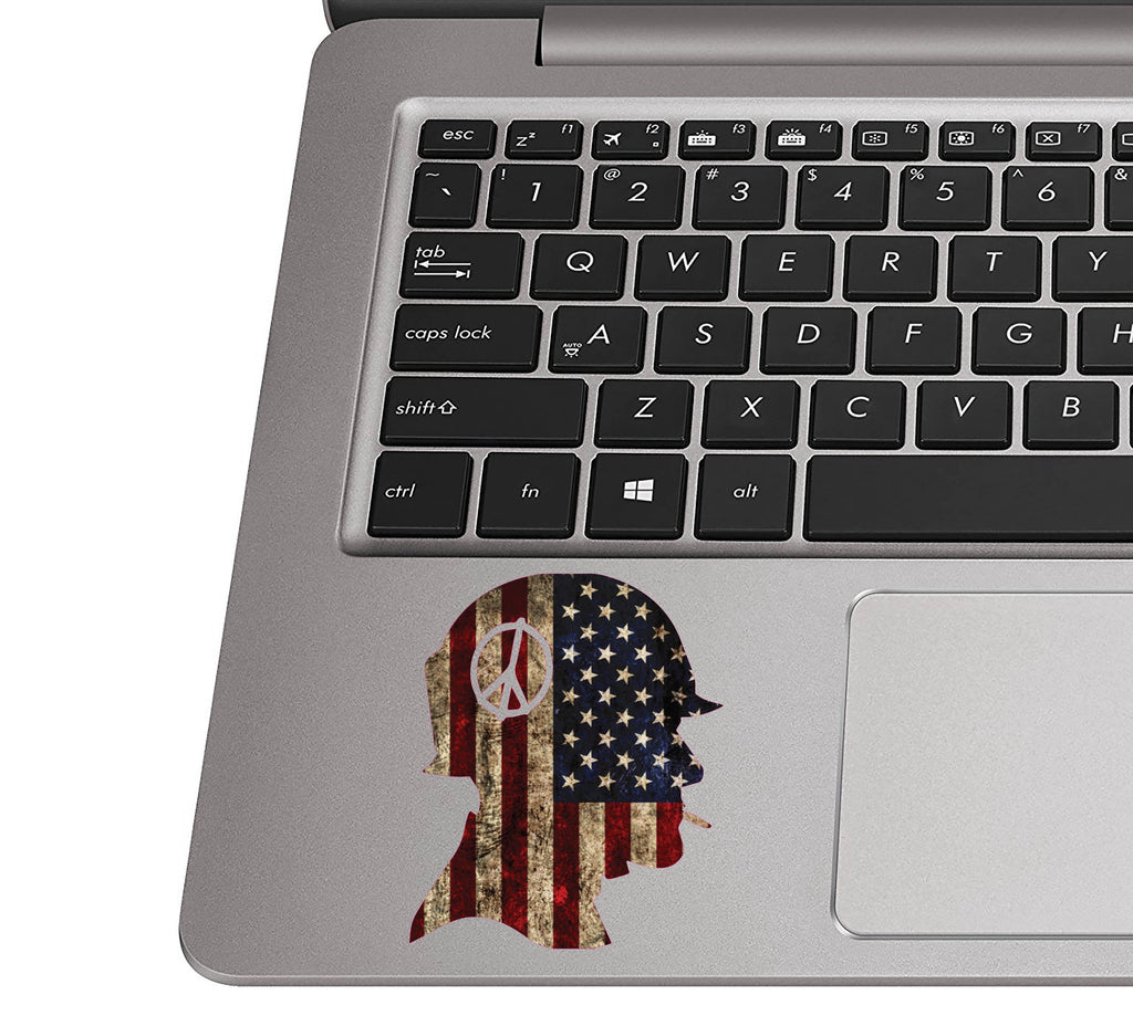 Rustic flag soldier helmet sticker on a silver laptop palm rest near a black QWERTY keyboard for sizing