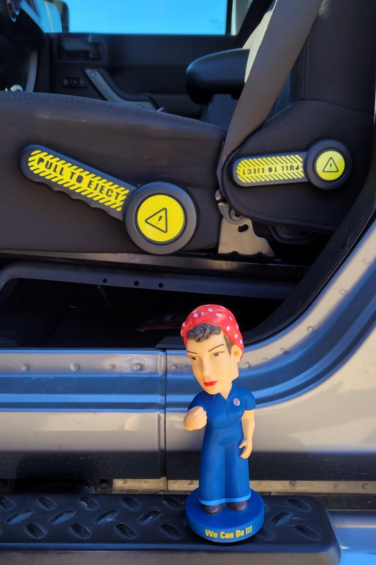 Yellow Pull to Eject seat recliner handle decals shown on Jeep JK with Rosie the Riveter figure