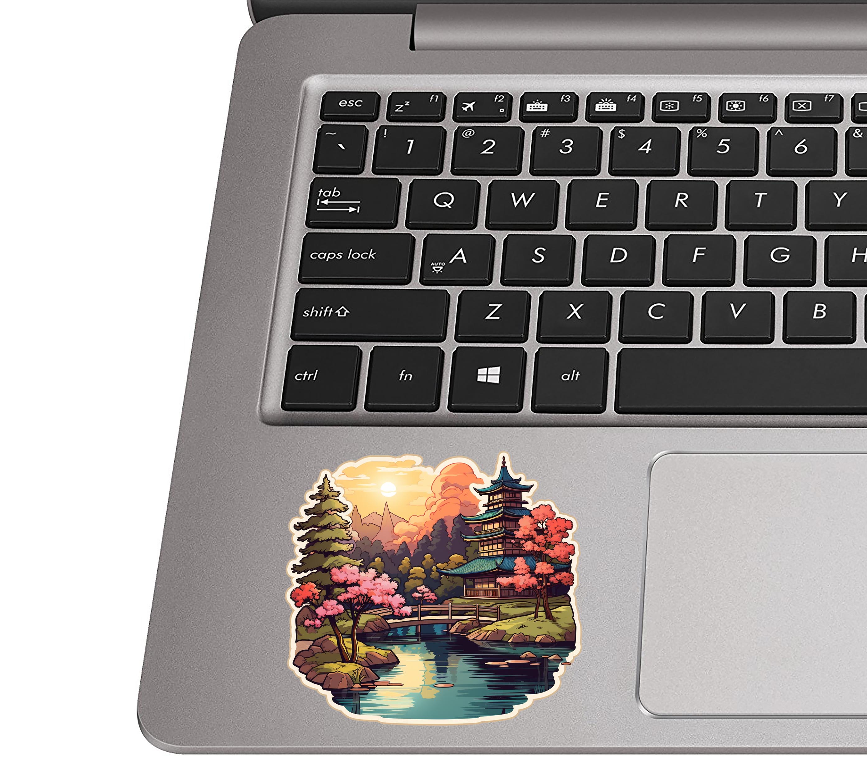 Pagoda garden sticker stuck to a silver laptop palm rest beside the keyboard showing the decal dimensions
