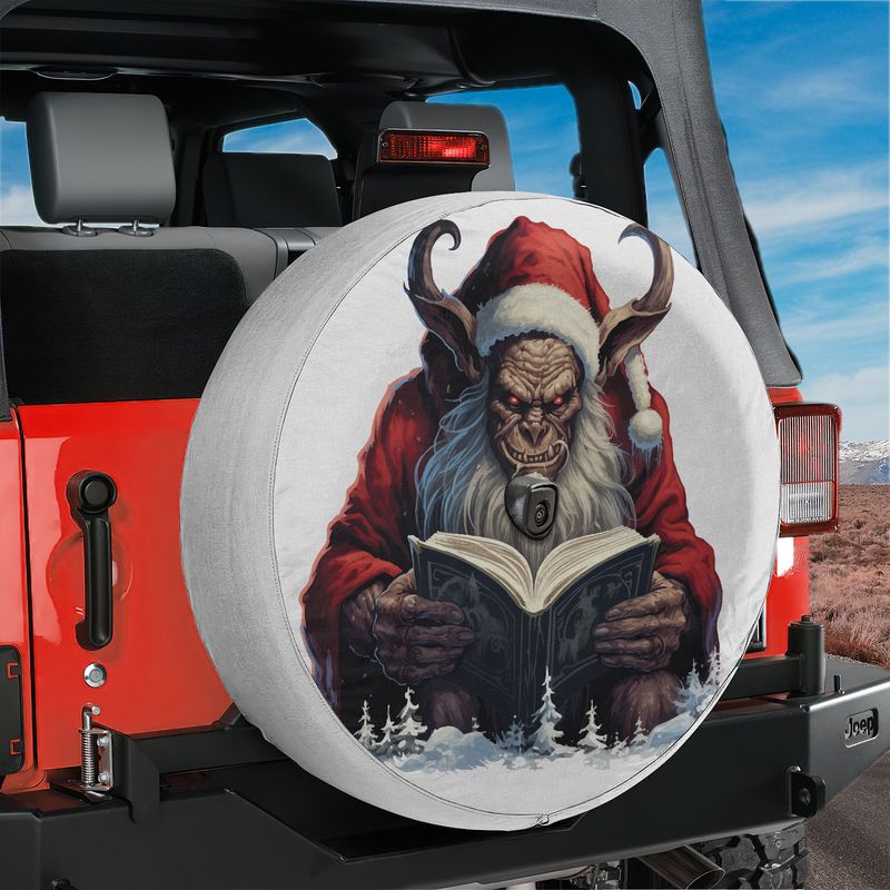 Krampus reading book spare tire cover mounted on a black Jeep Wrangler with desert background
