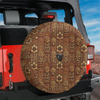 Tiki Wood Hawaiian carved face spare tire cover on red Jeep Wrangler with desert mountain horizon view