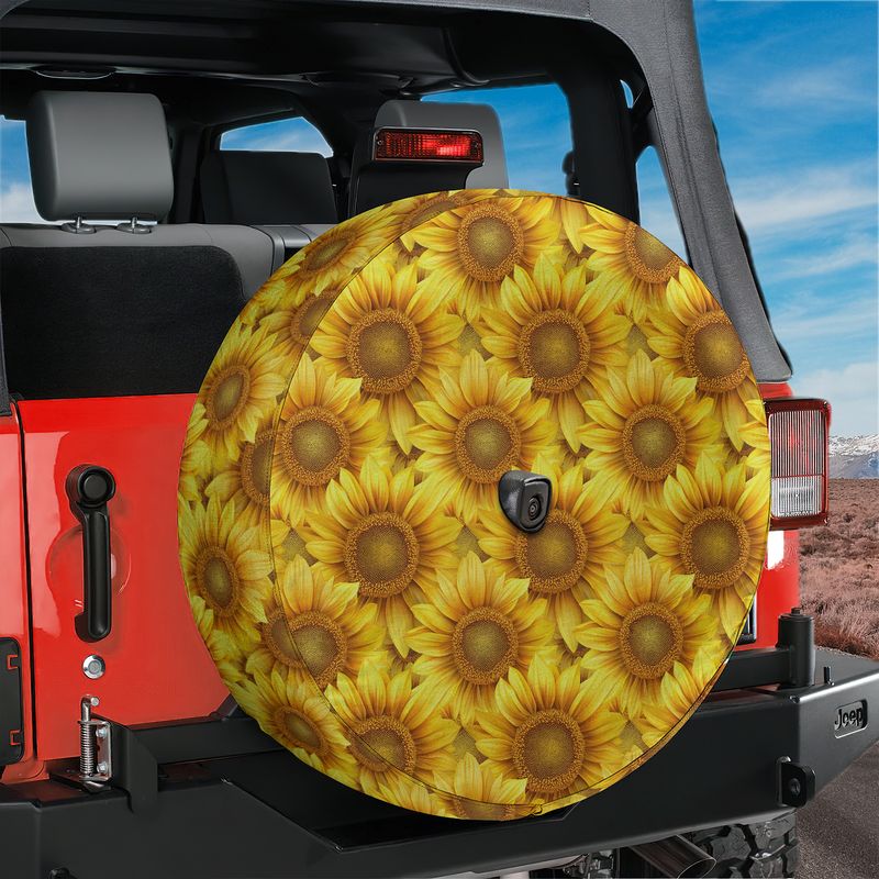 Sunflower field tire cover on red Jeep Wrangler with vivid yellow sunflowers and visible backup camera cutout